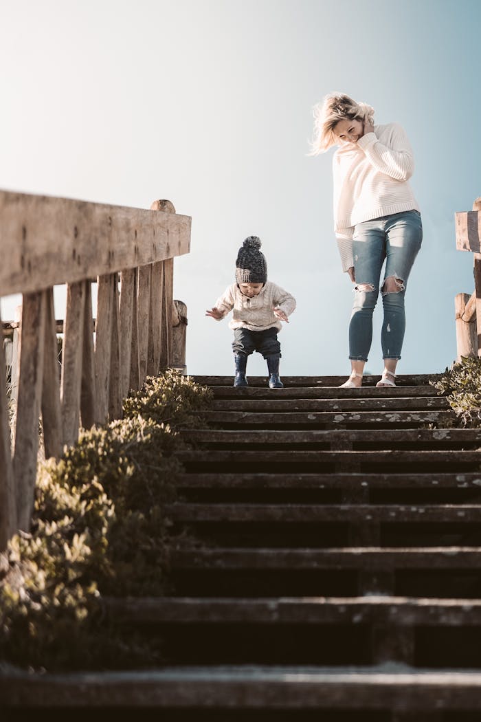 project-03-b A mother and child enjoying a sunny outdoor moment on wooden stairs, expressing bonding and joy.